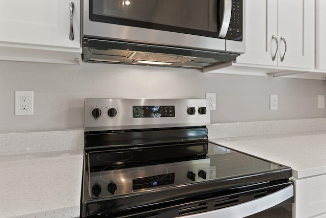 2891 N 8th St, Saint Augustine, FL 32084 - kitchen view of stainless steel appliances, white cabinetry, and light stone counters