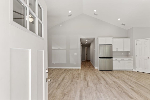 2891 N 8th St, Saint Augustine, FL 32084 - kitchen with freestanding refrigerator, white cabinetry, high vaulted ceiling, light wood-type flooring, and light countertops