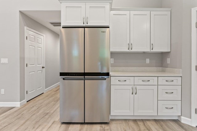 2891 N 8th St, Saint Augustine, FL 32084 - kitchen featuring freestanding refrigerator, light countertops, light wood-style flooring, and white cabinetry