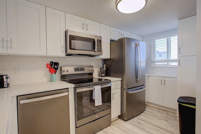 390 A1A Beach Blvd Unit 43, Saint Augustine Beach, FL 32080 - kitchen featuring appliances with stainless steel finishes, a textured ceiling, white cabinetry, and tasteful backsplash