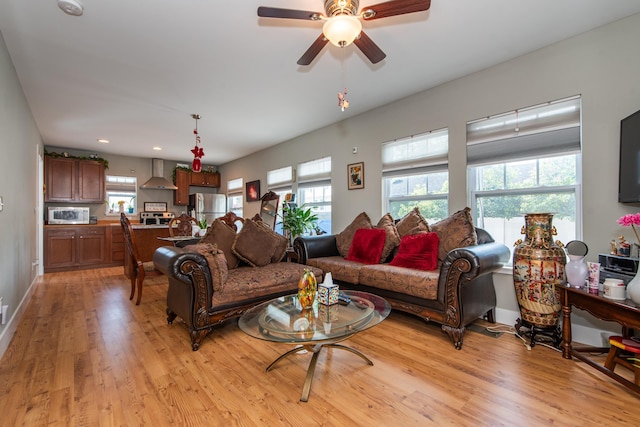 living room featuring ceiling fan, plenty of natural light, and light hardwood / wood-style flooring