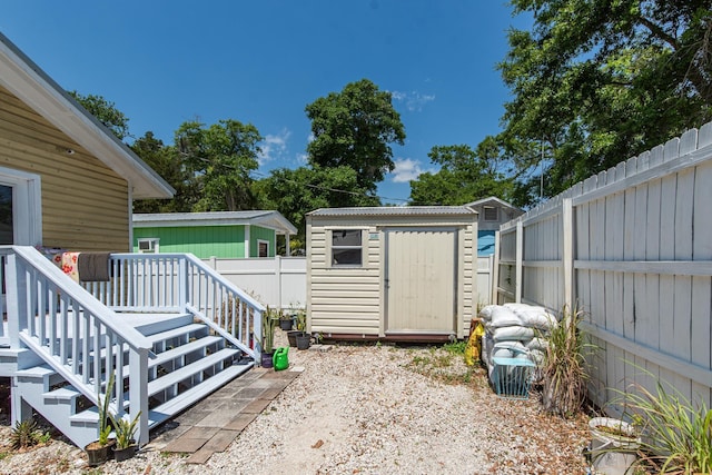 exterior space featuring a storage unit and a wooden deck