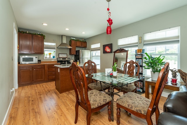 dining room with a wealth of natural light and light hardwood / wood-style flooring