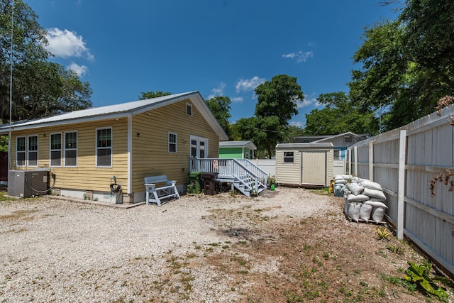 exterior space featuring a storage unit, cooling unit, and a wooden deck