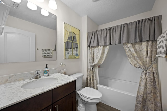 full bathroom with shower / bath combination with curtain, hardwood / wood-style flooring, vanity, toilet, and a textured ceiling