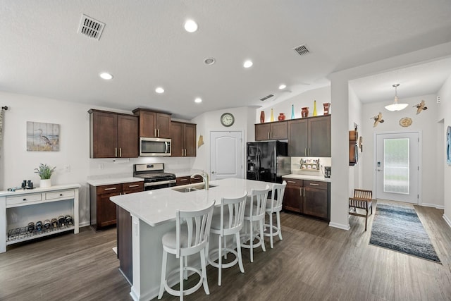 kitchen featuring sink, stainless steel appliances, dark hardwood / wood-style floors, dark brown cabinetry, and an island with sink