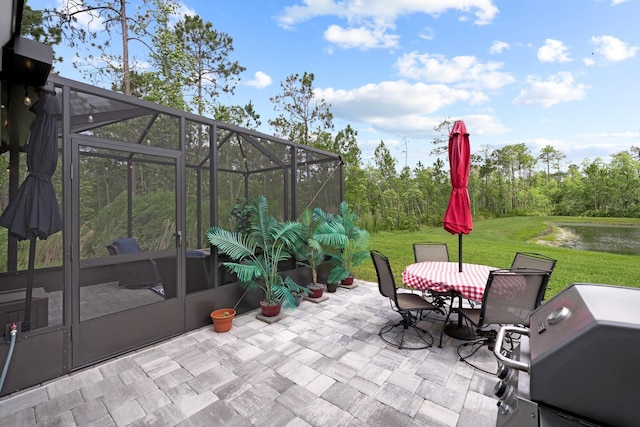 view of patio / terrace featuring a water view, area for grilling, and a lanai