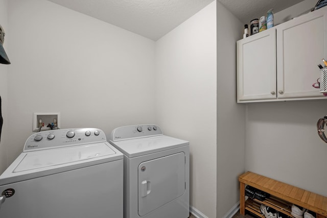 washroom featuring cabinets, washer and dryer, and a textured ceiling