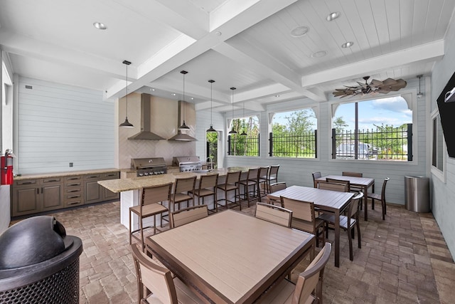 dining space featuring sink and beamed ceiling