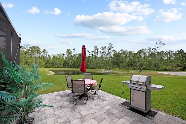 view of patio featuring grilling area, glass enclosure, and a water view