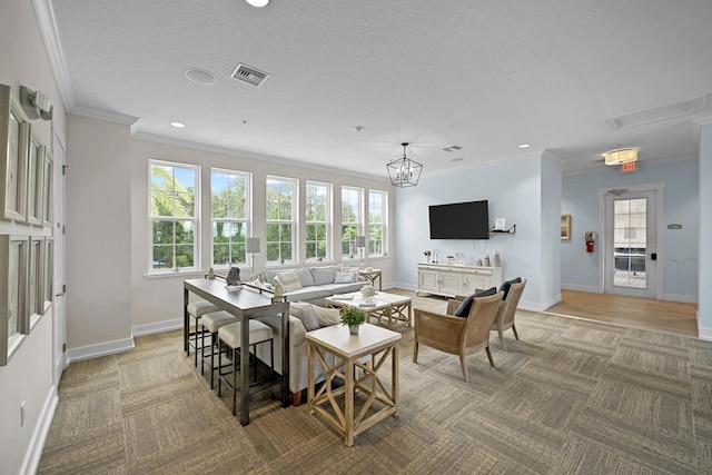 carpeted living room with ornamental molding, a wealth of natural light, a notable chandelier, and a textured ceiling