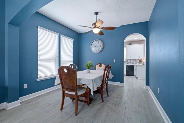 201 N Saxxon Rd, Saint Augustine, FL 32092 - dining space with a ceiling fan, a textured ceiling, arched walkways, baseboards, and light wood-style flooring