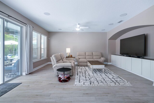 201 N Saxxon Rd, Saint Augustine, FL 32092 - living room featuring a ceiling fan, a textured ceiling, baseboards, and light wood finished floors