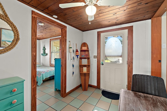 entryway featuring a ceiling fan, light tile patterned flooring, wood ceiling, and baseboards