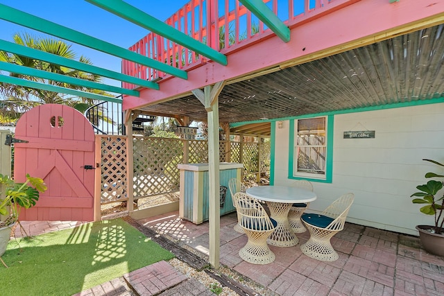 view of patio / terrace with a gate, fence, and outdoor dining space