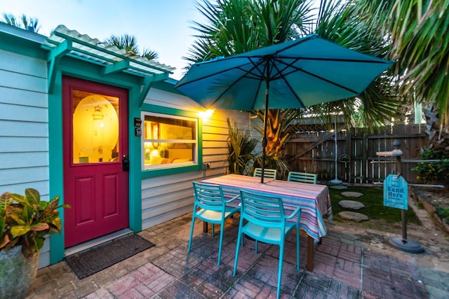 view of patio featuring outdoor dining area and fence