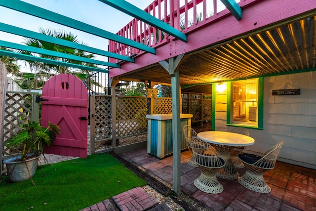 view of patio with outdoor dining area, fence, and a gate