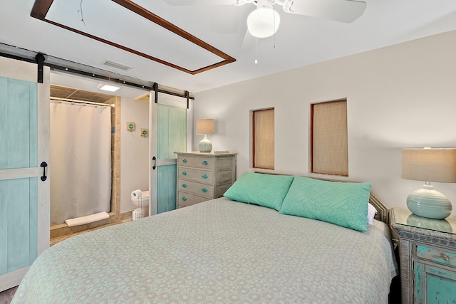 bedroom with ceiling fan, a barn door, a closet, and visible vents