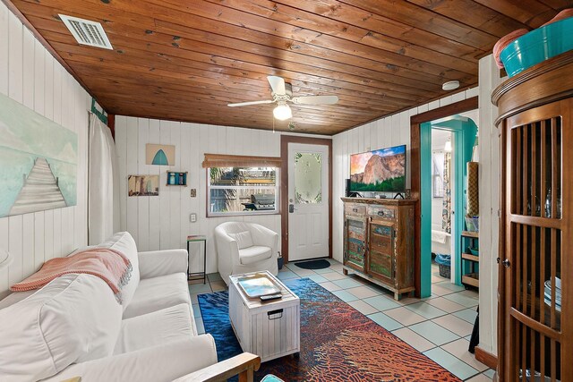 living area featuring light tile patterned floors, wooden ceiling, visible vents, and a ceiling fan