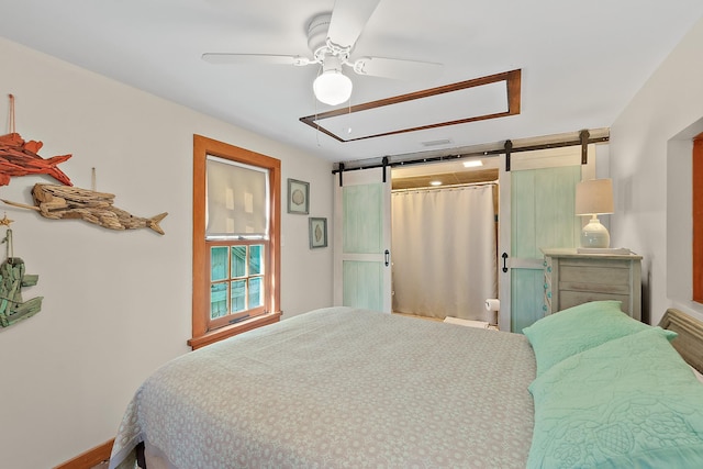 bedroom with visible vents, ceiling fan, and a barn door