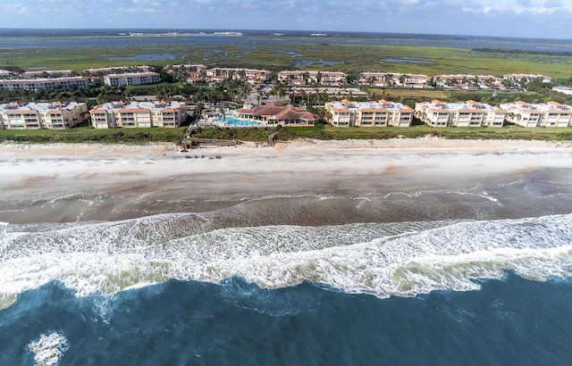 drone / aerial view with a water view and a beach view