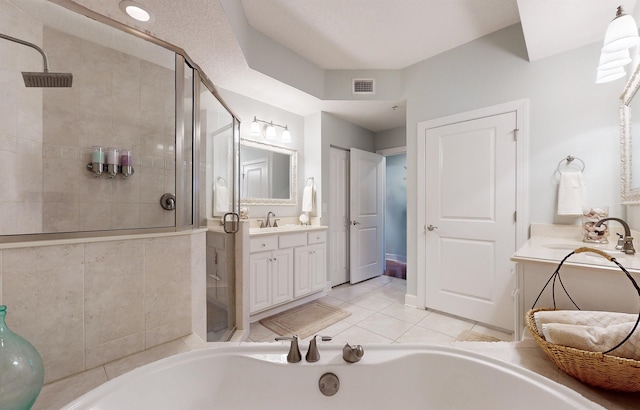 bathroom with visible vents, a garden tub, a stall shower, tile patterned floors, and vanity