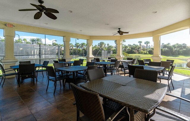 sunroom / solarium featuring a healthy amount of sunlight, ornate columns, and ceiling fan