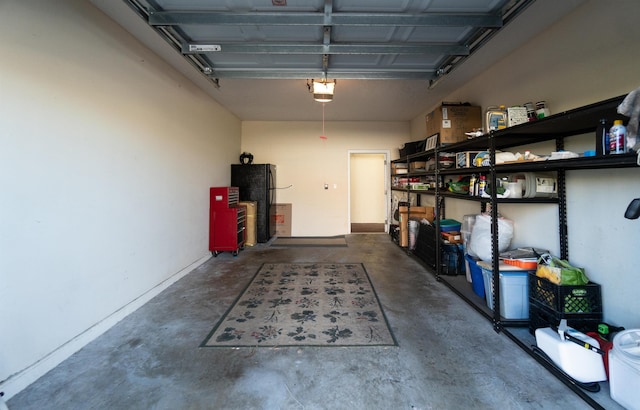 garage featuring freestanding refrigerator and a garage door opener