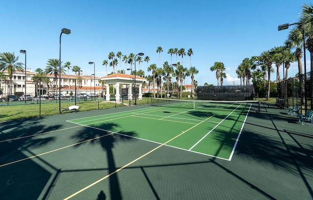 view of tennis court featuring fence