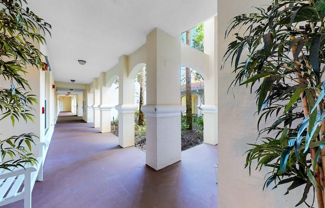 hall with arched walkways and concrete flooring