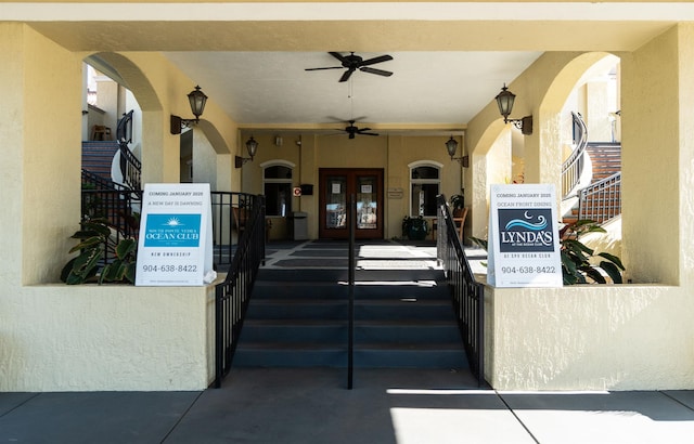 view of exterior entry with a ceiling fan, french doors, and stucco siding