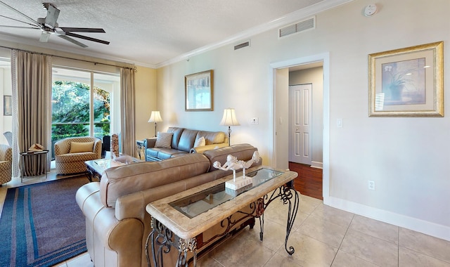 living area with visible vents, a textured ceiling, a ceiling fan, and crown molding