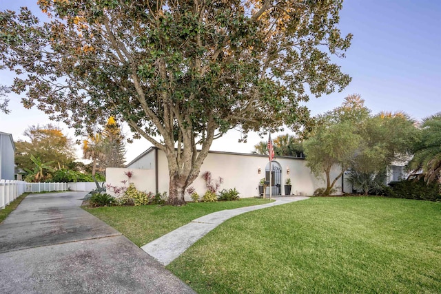 101 Dolphin Dr, Saint Augustine, FL 32080 - exterior space featuring a front lawn, driveway, stucco siding, and fence