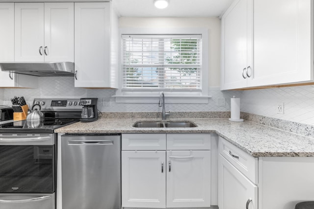 91 Saint Benedict St, Saint Augustine, FL 32084 - kitchen with appliances with stainless steel finishes, under cabinet range hood, white cabinetry, a sink, and decorative backsplash