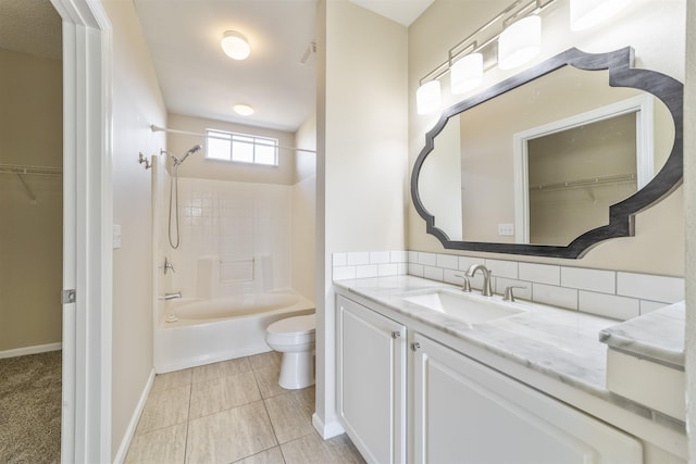 bathroom featuring tile patterned flooring, toilet, vanity, baseboards, and shower / bathing tub combination