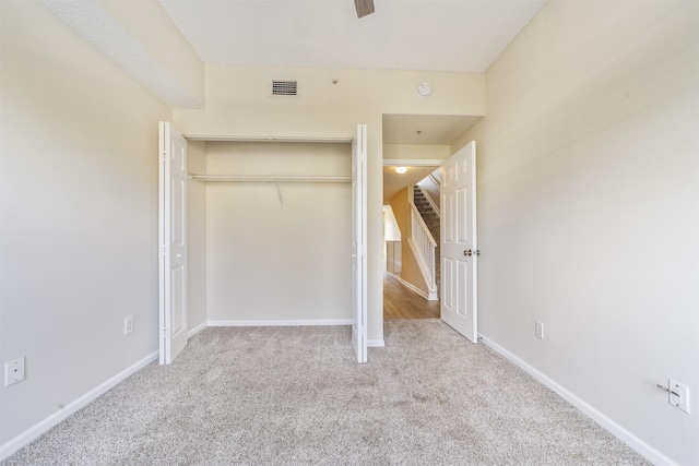unfurnished bedroom with carpet, a closet, visible vents, and baseboards