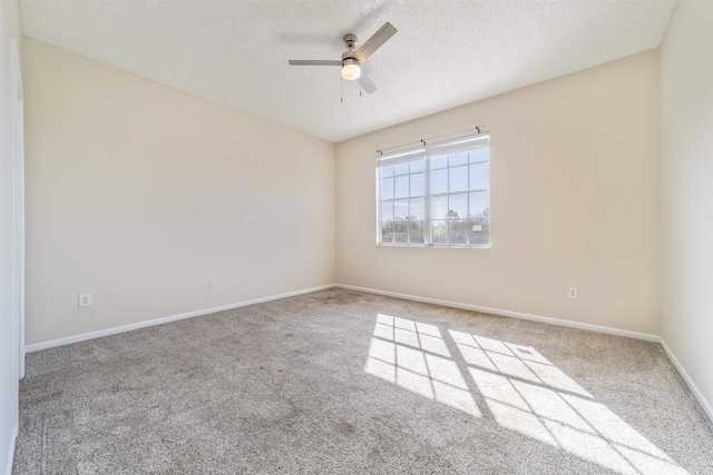 empty room with a textured ceiling, baseboards, a ceiling fan, and carpet flooring