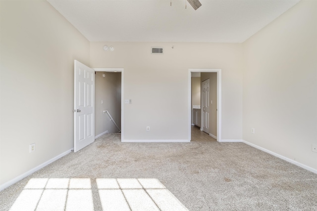 carpeted spare room featuring visible vents, baseboards, and a ceiling fan