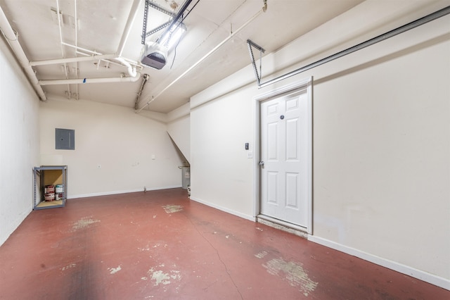 garage featuring a garage door opener, electric panel, and baseboards
