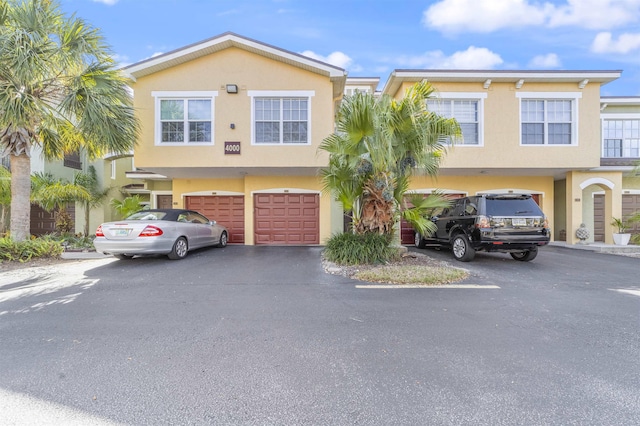 townhome / multi-family property featuring an attached garage, driveway, and stucco siding