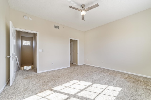 unfurnished bedroom with light colored carpet, visible vents, ceiling fan, and baseboards