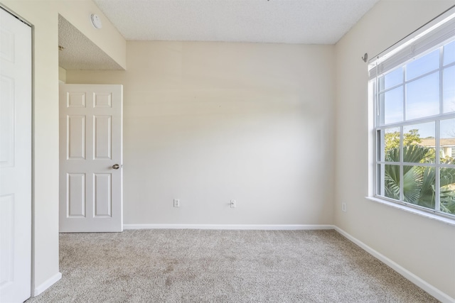 carpeted spare room featuring baseboards