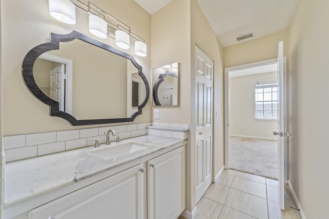 bathroom with visible vents, vanity, baseboards, and tile patterned floors