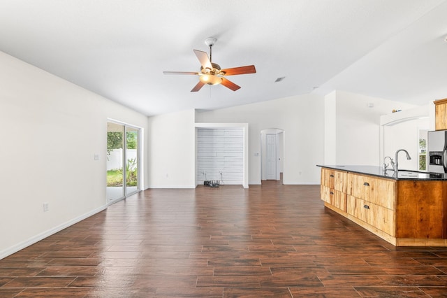 17 Porter Ln, Palm Coast, FL 32164 - unfurnished living room featuring vaulted ceiling, ceiling fan, arched walkways, dark wood finished floors, and baseboards