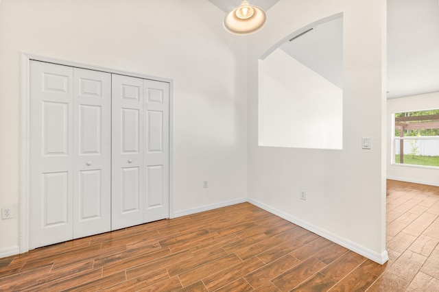 17 Porter Ln, Palm Coast, FL 32164 - unfurnished bedroom with wood finished floors, arched walkways, and baseboards