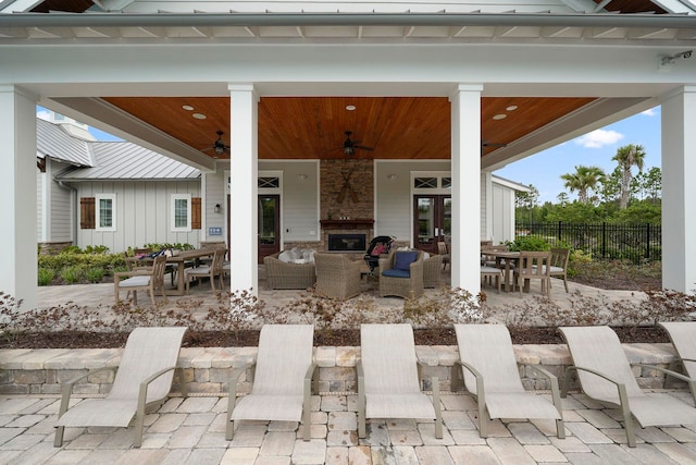 view of patio / terrace with ceiling fan and an outdoor living space with a fireplace