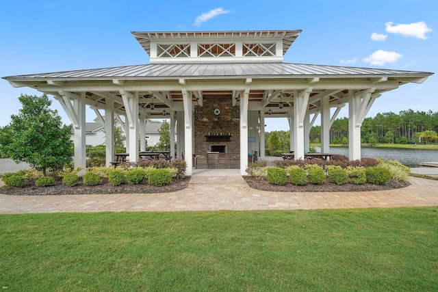 view of property's community with a water view and a lawn