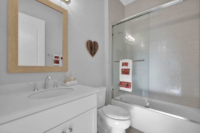 full bathroom with shower / bath combination with glass door, vanity, and toilet