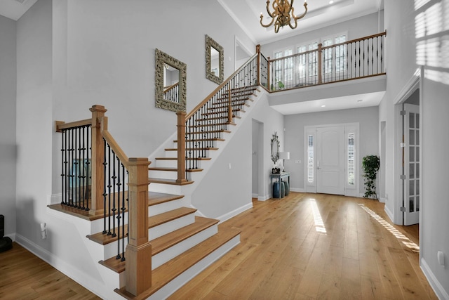 foyer with plenty of natural light, light hardwood / wood-style floors, and a high ceiling