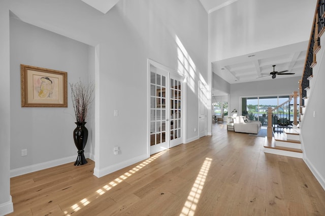 interior space with light hardwood / wood-style floors, beam ceiling, and coffered ceiling